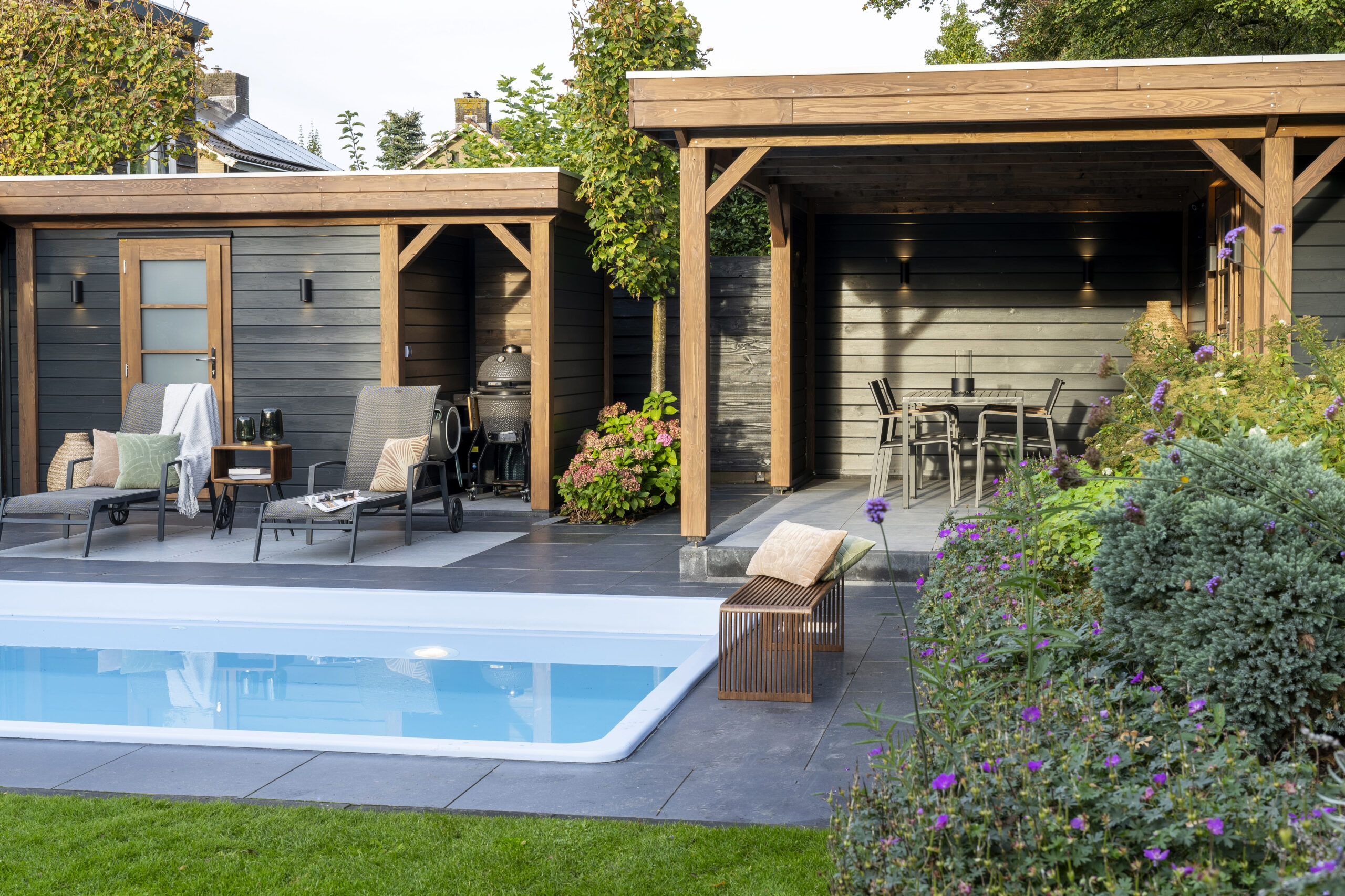 Modernes Poolhaus von Lugarde mit großer Glasfront, elegante Lounge am Wasser, witterungsbeständig, luxuriöser Look, edel.