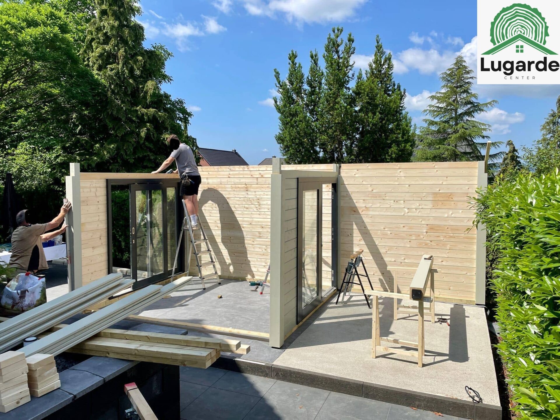 Montagefoto Terrasse: Kieselgraues Flachdachhaus mit Glasfront, weit auskragender Dachüberstand, Sitzecke, Grillplatz.