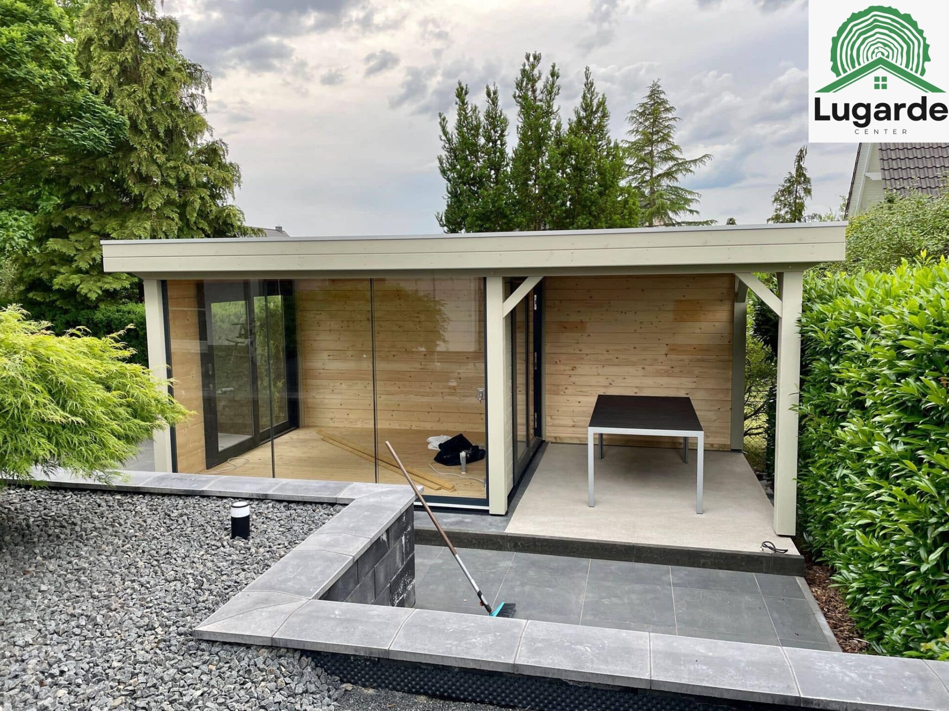 Fertig montiert: Lugarde Pro System in Kieselgrau, großzügige Glasfront, großer Dachüberstand mit Sitzecke, Grillbereich.
