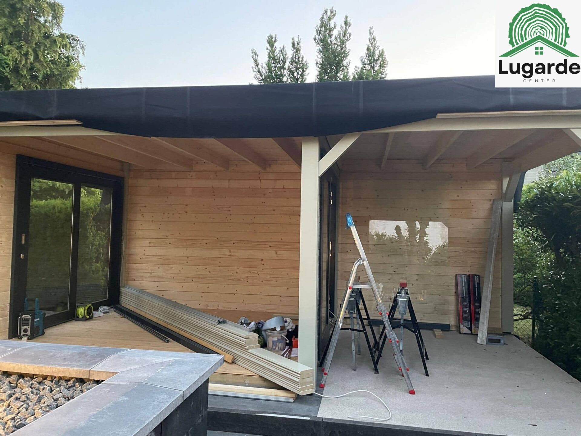 Pro System, Kieselgrau: Schattenwurf des Dachüberstands über der Sitzecke; Glasfront öffnet zum Grill-Outdoor-Bereich.