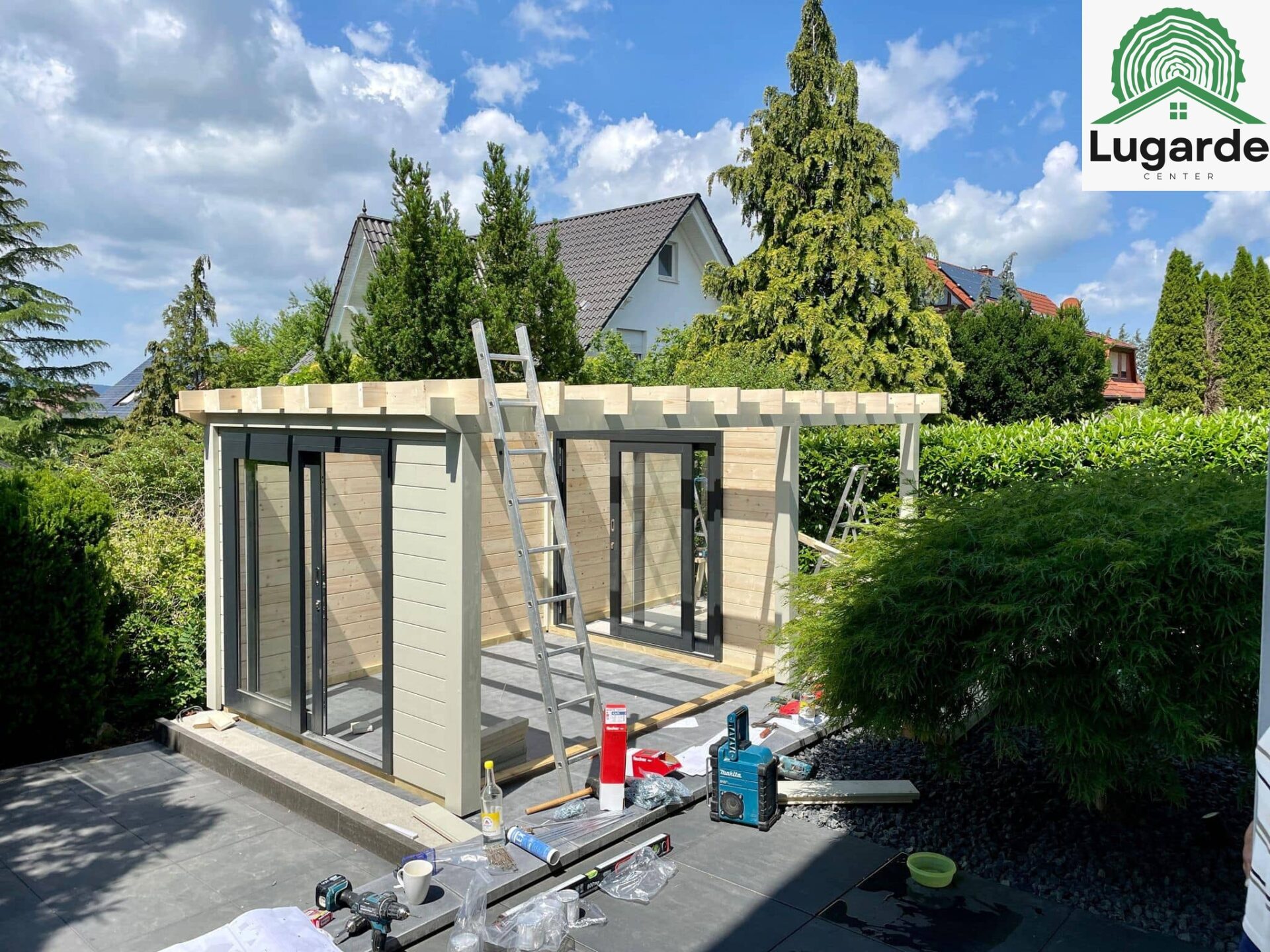 Möblierte Sitzecke unter Dachüberstand, Lugarde Pro System in Kieselgrau; große Glasfront, Grillbereich in Terrassennähe.