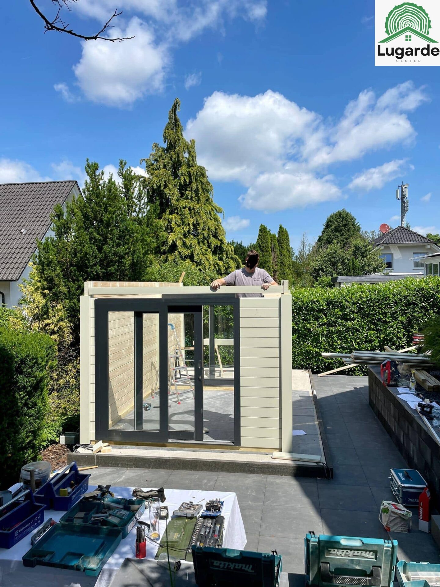 Pro System Kieselgrau, Detail Attika/Dachrinne; große Glasfront, überdachte Sitzecke darunter, Outdoor-Grillbereich.