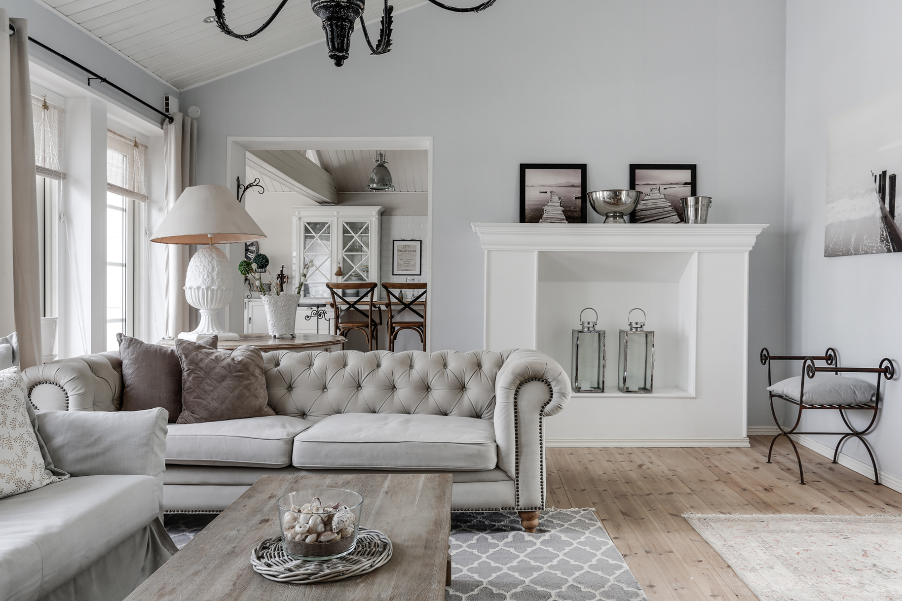 Tiny Haus Innenraum von Lugarde, lichtdurchflutet mit Glasfront und Schiebetüren, offener Wohnbereich mit Sofa und Essplatz.