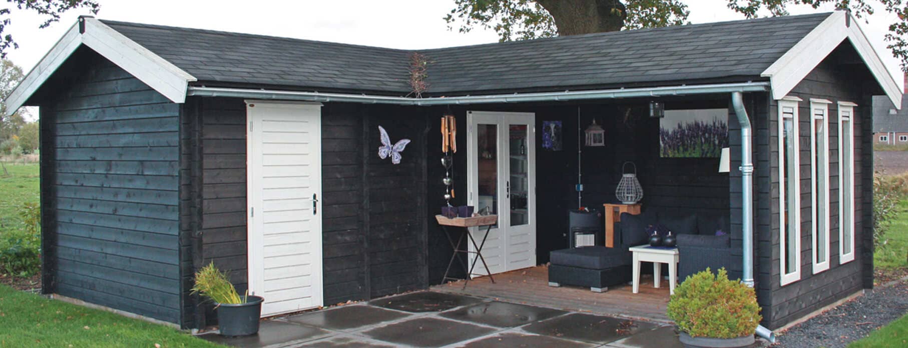 Geräumiges Tiny House als Gäste-Lodge mit seitlicher Außenterrasse und viel Glasfront, entworfen vom Lugarde-Center.